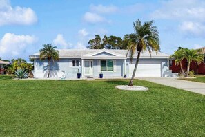 A single-story house with a front porch, a garage, and a well-maintained lawn. - Coastal home with private, saltwater pool, gas grill, and internet (Punta Gorda)
