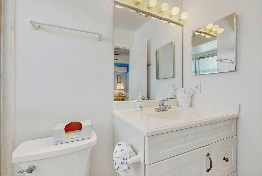 A bathroom with a white sink, mirror, and towel rack.