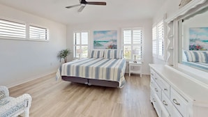 A bedroom with a bed, a dresser, a ceiling fan, and a window with blinds. - Spacious Duplex with two kitchens, W/D, and WiFi throughout (Englewood)