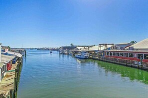 A marina with boats docked, a pier with buildings, and a clear blue sky. - Beautiful home w/ heated in ground pool, wifi, dog-friendly, and sundeck (Naples)