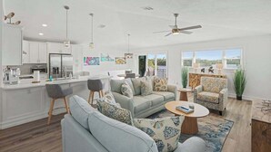 A modern living space with a kitchen, dining area, and seating area. - Immaculate bay front home w/in ground pool, spa, paver patio & porch (Bonita Springs)