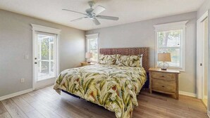 A bedroom with a bed, a ceiling fan, a nightstand, and a window. - Spacious home with private saltwater heated pool, gas grill, close to the beach (Venice)