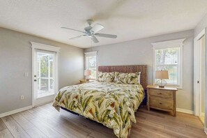 A bedroom with a bed, a ceiling fan, a nightstand, and a window. - Spacious home with private saltwater heated pool, gas grill, close to the beach (Venice)