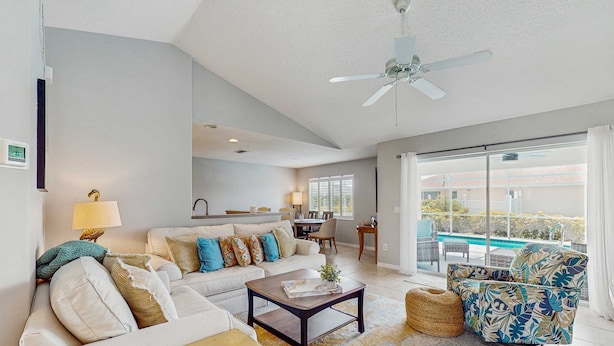 A modern living room with a sofa, coffee table, and a view of a swimming pool. - Spacious home with private saltwater heated pool, gas grill, close to the beach (Venice)