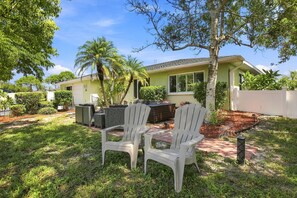 A residential property with a patio area featuring two Adirondack chairs, a dining table, and a built-in barbecue grill. - Dog-friendly and Snowbird friendly close to beaches! (Venice)
