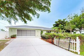 A single-story house with a garage, a white picket fence, and a well-maintained lawn. - Dog-friendly and Snowbird friendly close to beaches! (Venice)