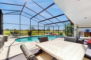 A covered outdoor area with a pool, seating, and a table. - Coastal home on golf course w/ water view, private pool & spa, AC, W/D, Wifi (Rotonda West)