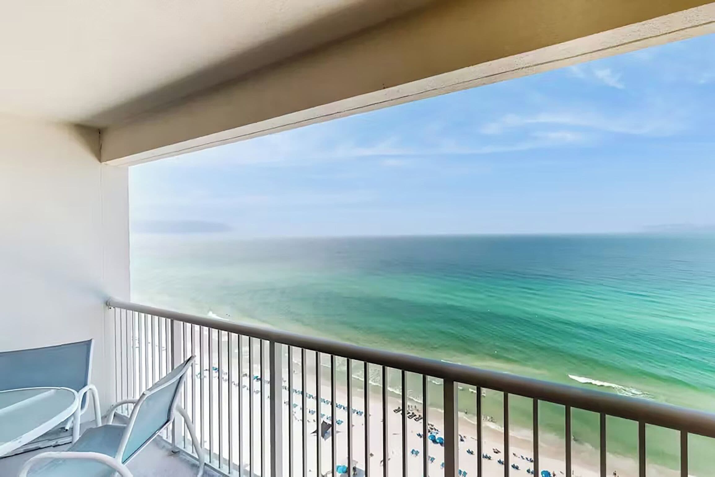 Ein Balkon mit Blick auf den Ozean und den Strand.
