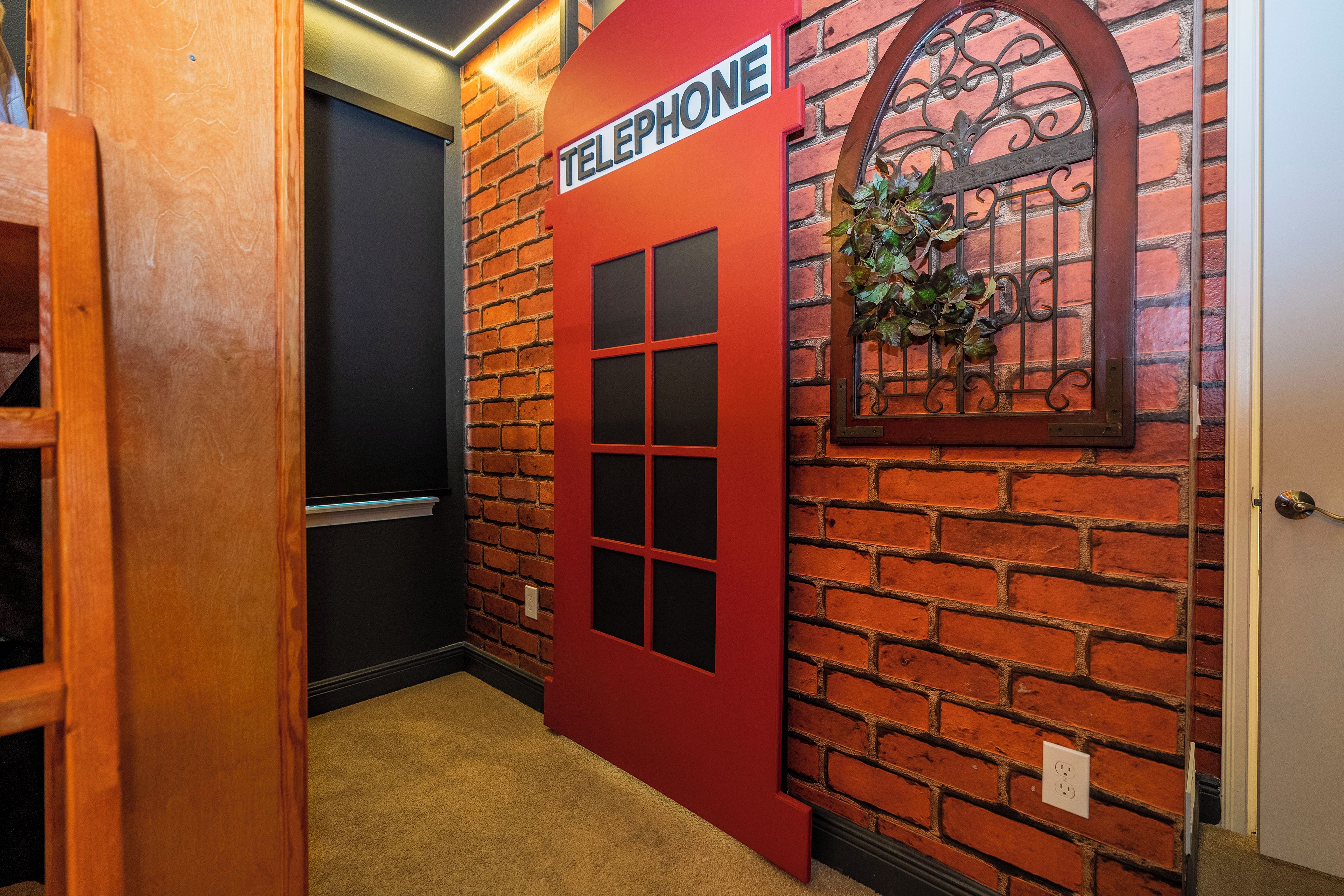 A hallway with a red door labeled 'TELEPHONE' and a brick wall.
