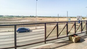 A balcony with a metal railing overlooking a road with a blue car passing by. - Blue Room - Double Room with Private Garage (Bitonto)