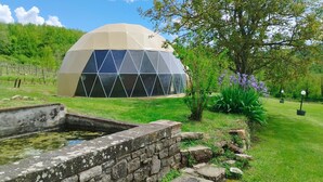 A geodesic dome structure with a stone wall and a small pond. - Wonderful private villa with private pool, hot tub, WIFI, TV, pets allowed and panoramic view (Monte Castello Di Vibio)