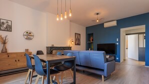 Un salon moderne comprenant un coin repas, un canapé et un téléviseur.