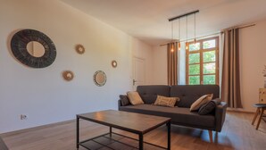 Un salon comprenant un canapé, une table basse et des œuvres d’art décoratives accrochées au mur.