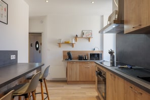 A modern kitchen with wooden cabinets, a countertop, and a built-in oven.