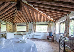 Une pièce avec un plafond en pente, un lit, une table avec des serviettes, un petit bureau et une chaise.