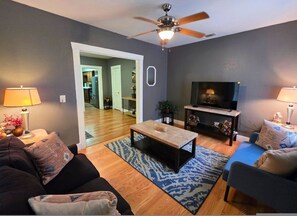 A living room with a ceiling fan, a TV, a coffee table, and two sofas. - Affordable Eado Stay Near Downtown Houston (Houston)