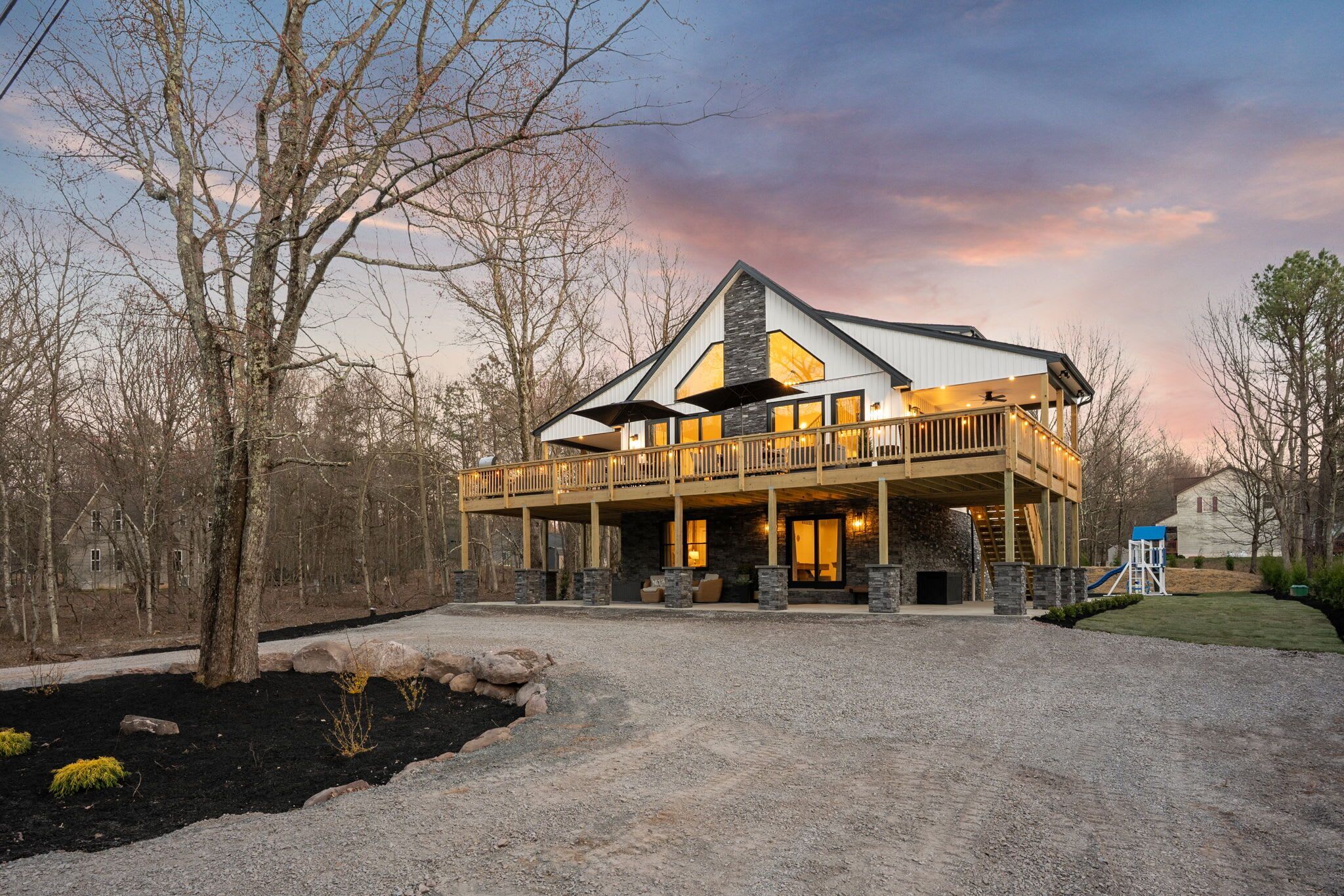 A large, multi-story house with a prominent front porch and a covered deck area.