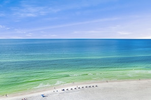 Ein Strand mit klarem, blauem Wasser und sandigem Ufer.