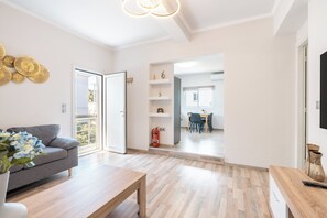 Ein modernes Wohnzimmer mit einer Couch, einem Couchtisch und einem Essbereich im Hintergrund.