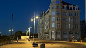 Een groot, historisch gebouw met een opvallende koepel en meerdere ramen, gelegen in een goed verlicht stadsgebied in de nacht.