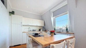 Een moderne keuken met witte kasten, een houten eiland en een raam met uitzicht.