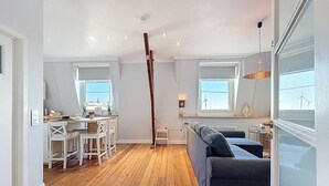 Een modern appartement met een eethoek, een bank en een trap.