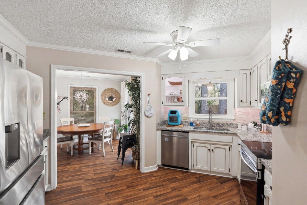 A kitchen with white cabinets, a stainless steel refrigerator, and a dishwasher.