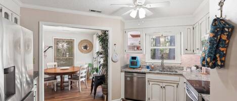 A kitchen with white cabinets, a stainless steel refrigerator, and a dishwasher.