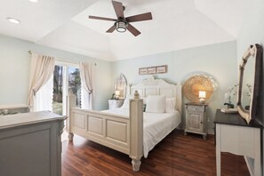 A bedroom with a bed, bedside tables, a ceiling fan, and a window with curtains. - Quiet 4BR Retreat Prefect for Families and Groups (Spartanburg)