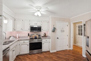A kitchen with white cabinets, a stainless steel oven, a microwave, and a ceiling fan. - Quiet 4BR Retreat Prefect for Families and Groups (Spartanburg)