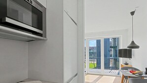 Una cucina moderna con forno a microonde, piano cottura a induzione e zona pranzo con tavolo e sedie.