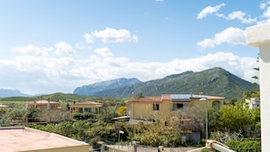 Un quartier résidentiel avec des maisons, une montagne et un ciel dégagé.