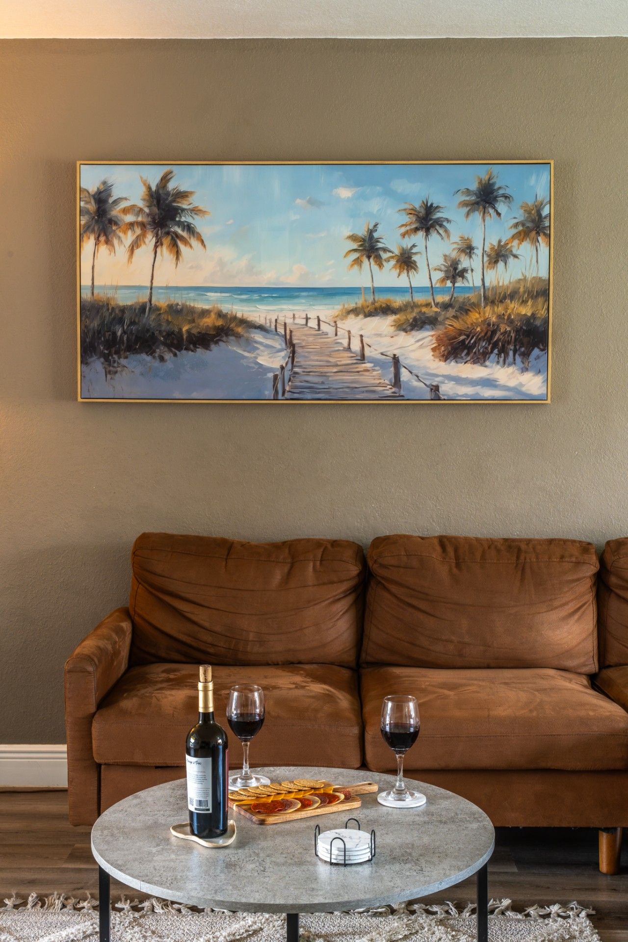 Living Room Coastal Wall Art: Bring the beach indoors with coastal-inspired artwork hanging above the comfortable plush sectional, creating a warm, inviting backdrop for group gatherings and lazy afternoon relaxation.