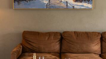 Living Room Coastal Wall Art: Bring the beach indoors with coastal-inspired artwork hanging above the comfortable plush sectional, creating a warm, inviting backdrop for group gatherings and lazy afternoon relaxation.