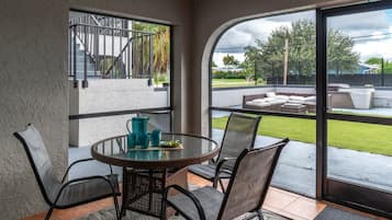 Private Screened Lanai & Patio: Sip your morning coffee or share cold drinks on this private covered screened lanai, complete with an outdoor patio dining table, comfortable woven seating, and direct views of the lush green yard space