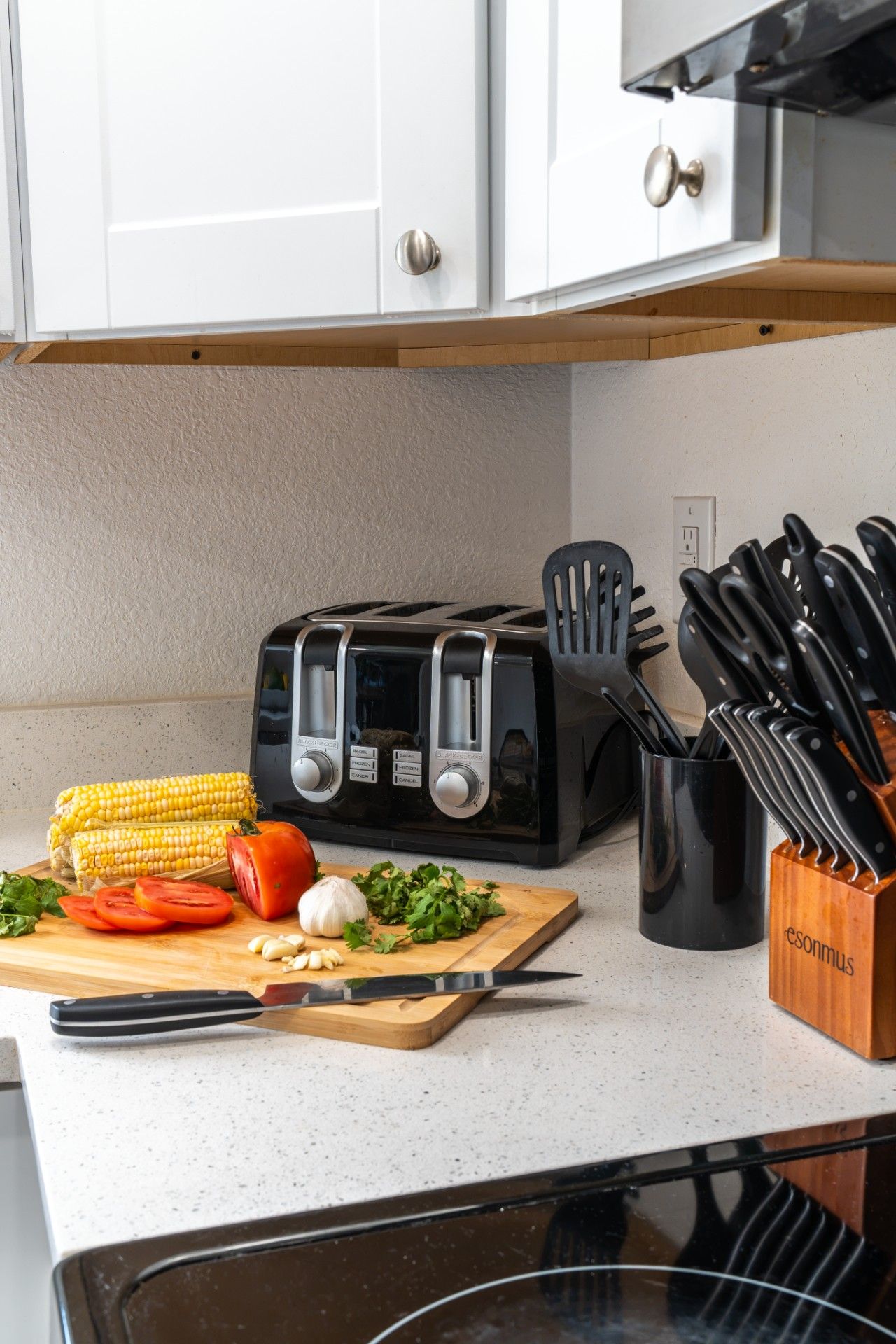Gourmet Small Appliance & Knife Station: Toast your morning breakfast or prepare fresh ingredients effortlessly using this modern kitchen counter setup, featuring a four-slice toaster, complete chef`s knife block, and essential cooking utensils.