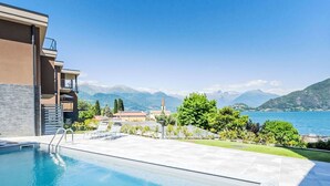 Una piscina con vistas a montañas y un lago.