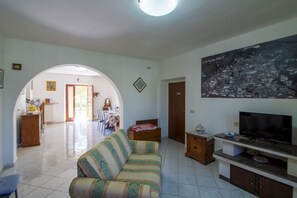 Ein Wohnzimmer mit einer Couch, einem Fernseher und einem Stadtbild.