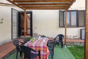 Eine Terrassensitzgruppe im Freien mit Tisch für zwei Personen, umgeben von Stühlen.