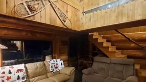 A wooden interior with a sofa, a bench, and a staircase.
