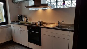 A modern kitchen with a built-in oven, a sink, and a window with a view. - The perfect time-out a small but fine accommodation in the heart of the Saarland? (Illingen)