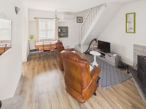 A living room with a sofa, a television, a fireplace, and a staircase. - House with pool 50 m from Lascaux IV for two (Montignac)