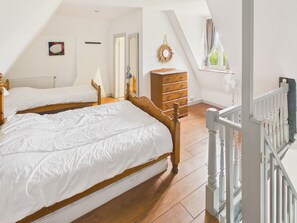A bedroom with two beds, a dresser, a mirror, a radiator, and a window with curtains. - House with pool 50 m from Lascaux IV for 3 (Montignac)