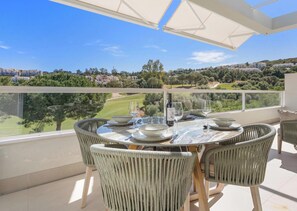 Un coin repas avec une table dressée pour deux personnes, offrant une vue sur un paysage magnifique.