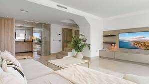 A modern living room with a sofa, a TV, and a potted plant. - The Don | Terrace - Views - Pool (La Cala de Mijas)