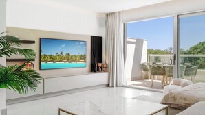 A modern living room with a flat-screen TV, a coffee table, and a balcony with outdoor seating. - The Don | Terrace - Views - Pool (La Cala de Mijas)