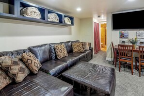 A living room with a leather sofa, ottoman, and patterned cushions. - Hot Tub and Pool access|On Green Run|Free Shuttle (Breckenridge)