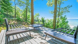 A wooden deck with benches overlooking a body of water. - Dog-friendly home with lake views, wood stove, kayaks/SUPs, & W/D (Coloma)