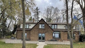 A two-story house with a brick facade, a front entrance, and a paved driveway.