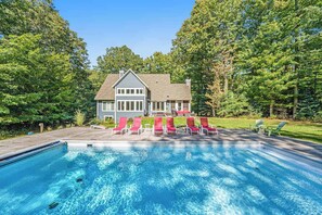 Ein Haus mit Schwimmbad, umgeben von Bäumen.